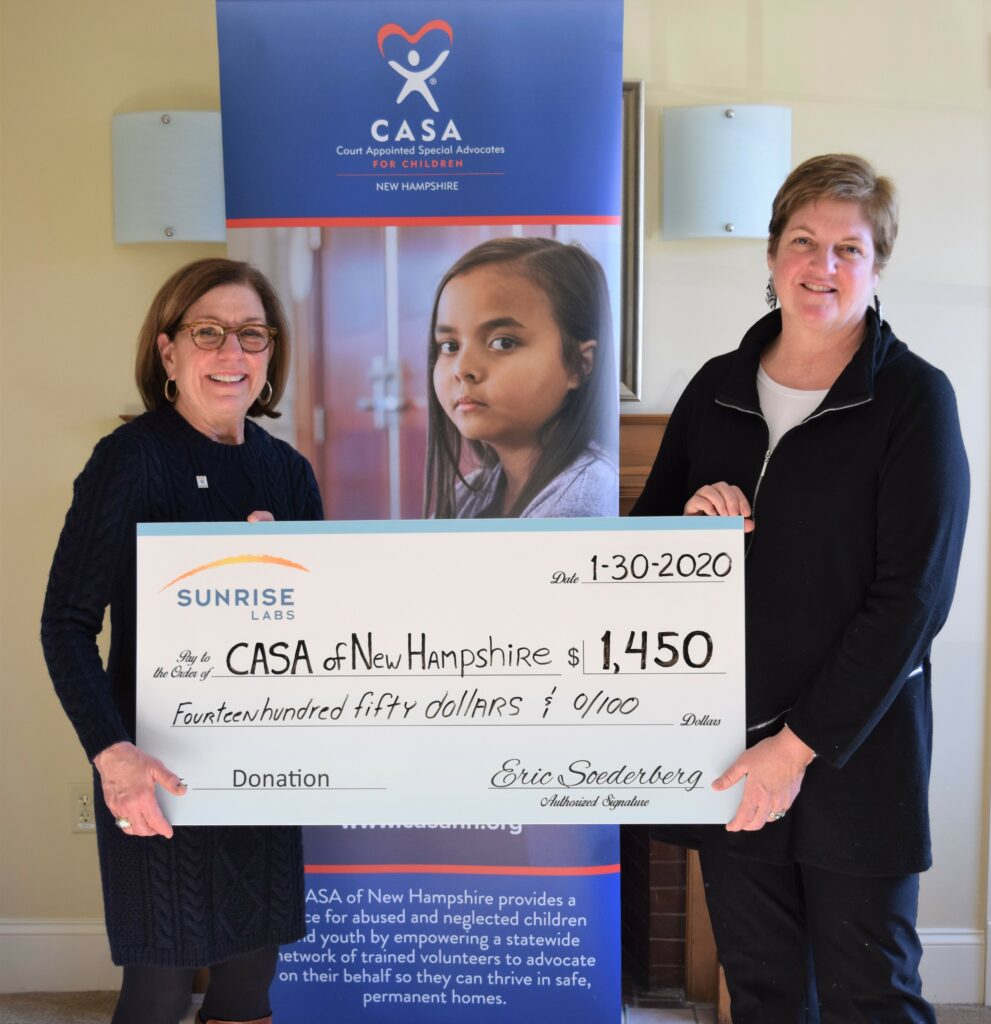 two women holding a big check