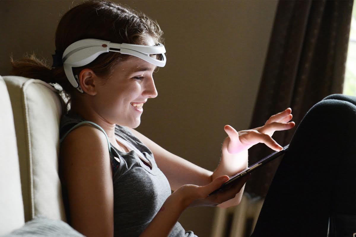 Girl with EEG monitoring headset and tablet